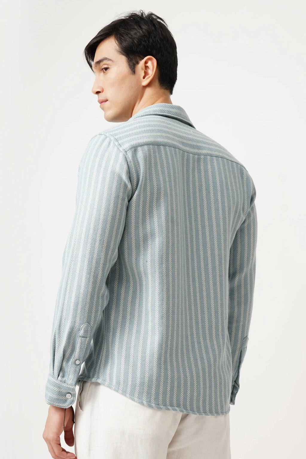 Man wearing Aqualure striped shirt, back view, showcasing premium brush fabric and relaxed fit design.