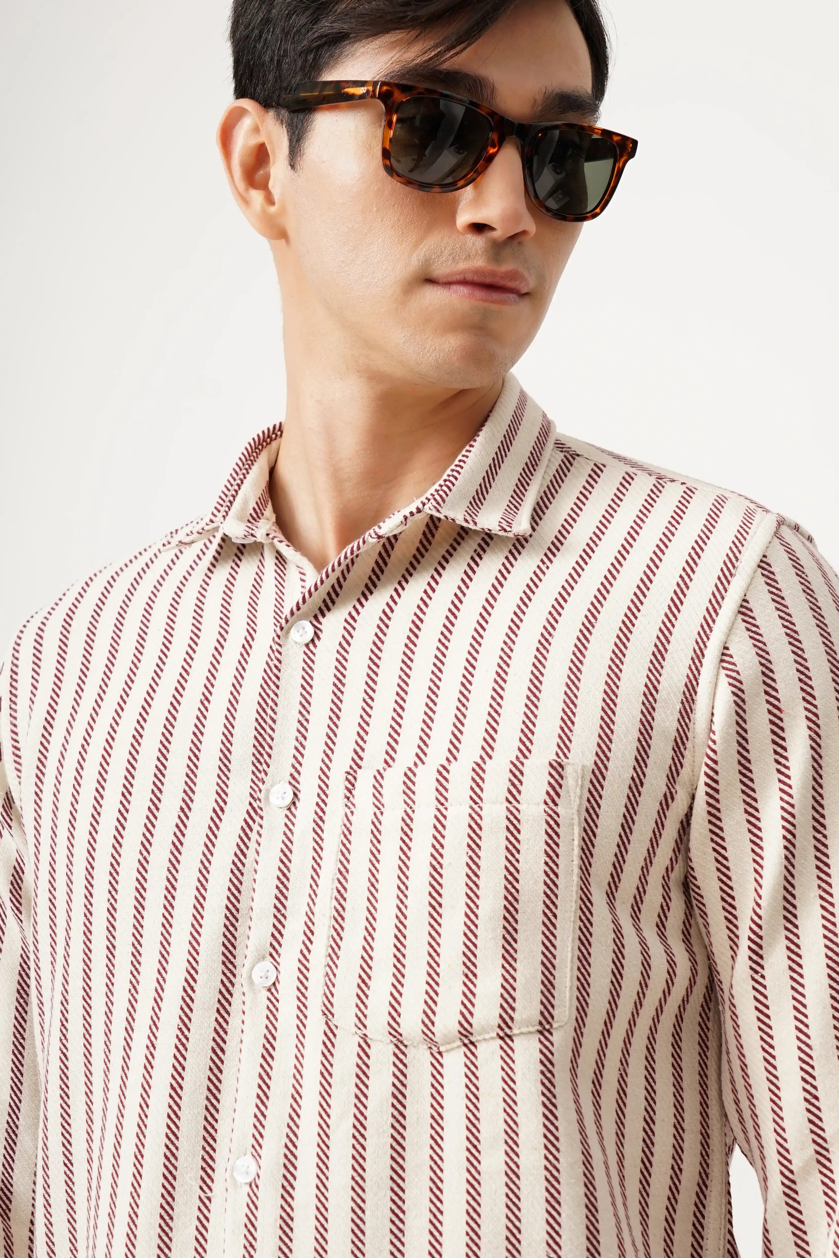 Man wearing Striluxe striped shirt with sunglasses, featuring a tailored silhouette and premium brush fabric.