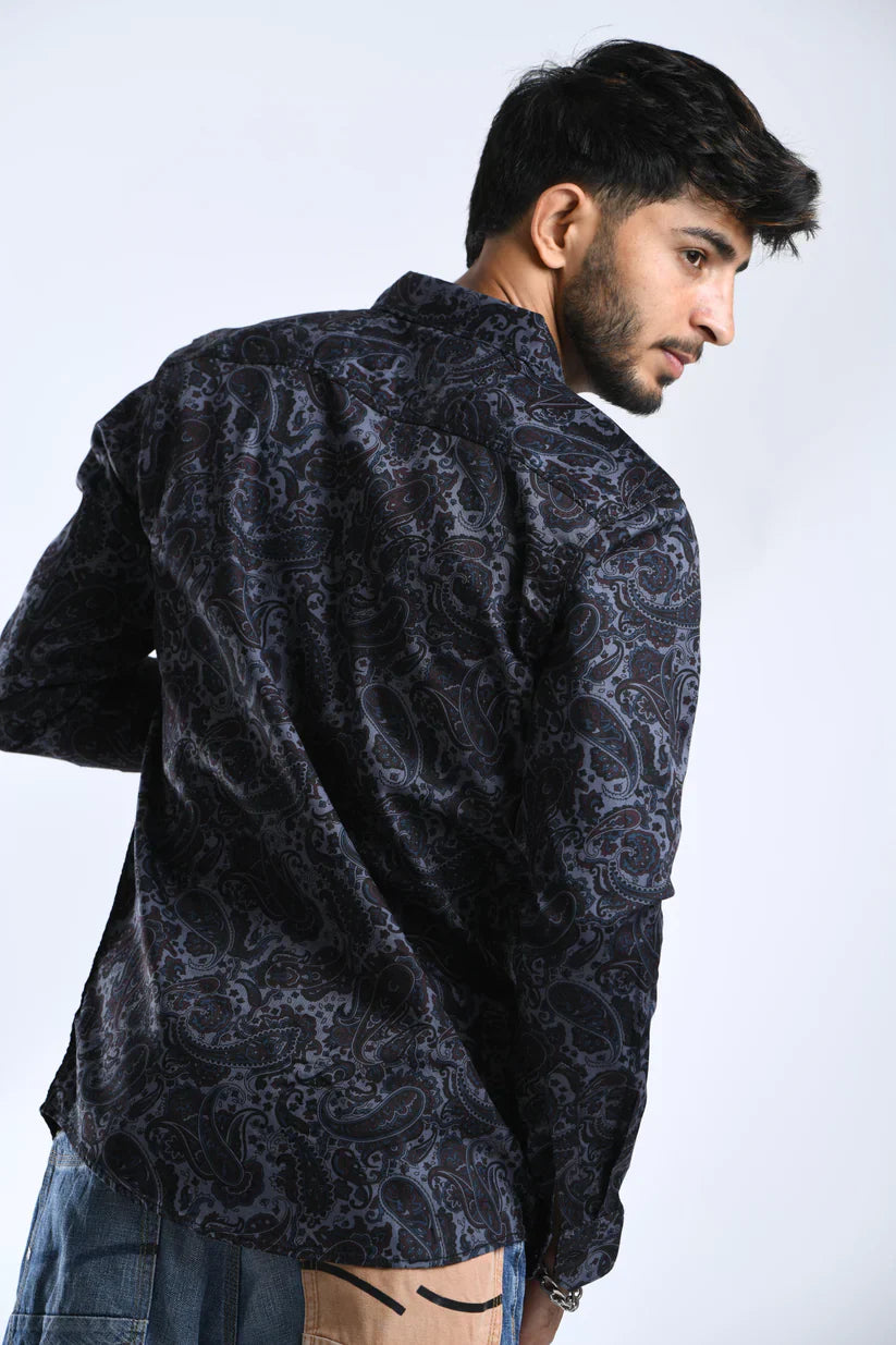 Man wearing a black printed shirt with grey patterns.