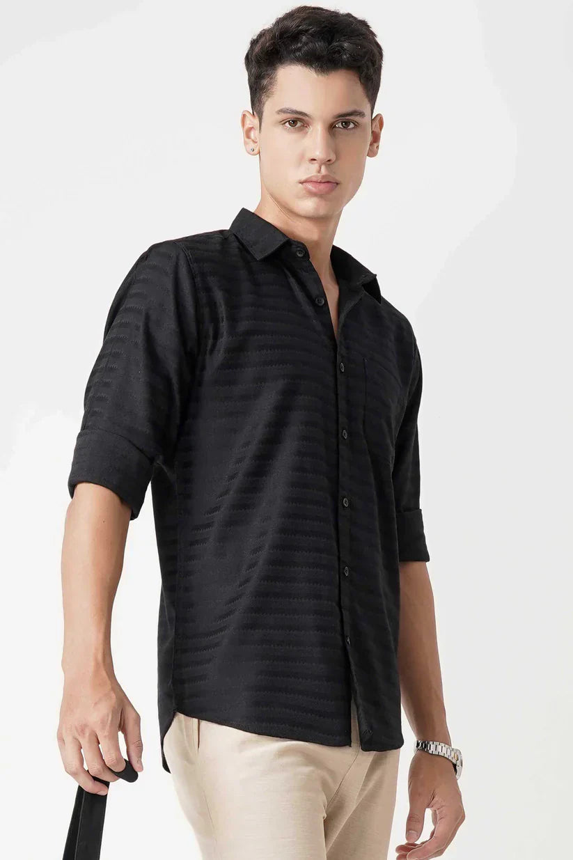 Man wearing black striped shirt made of 100% cotton fabric.