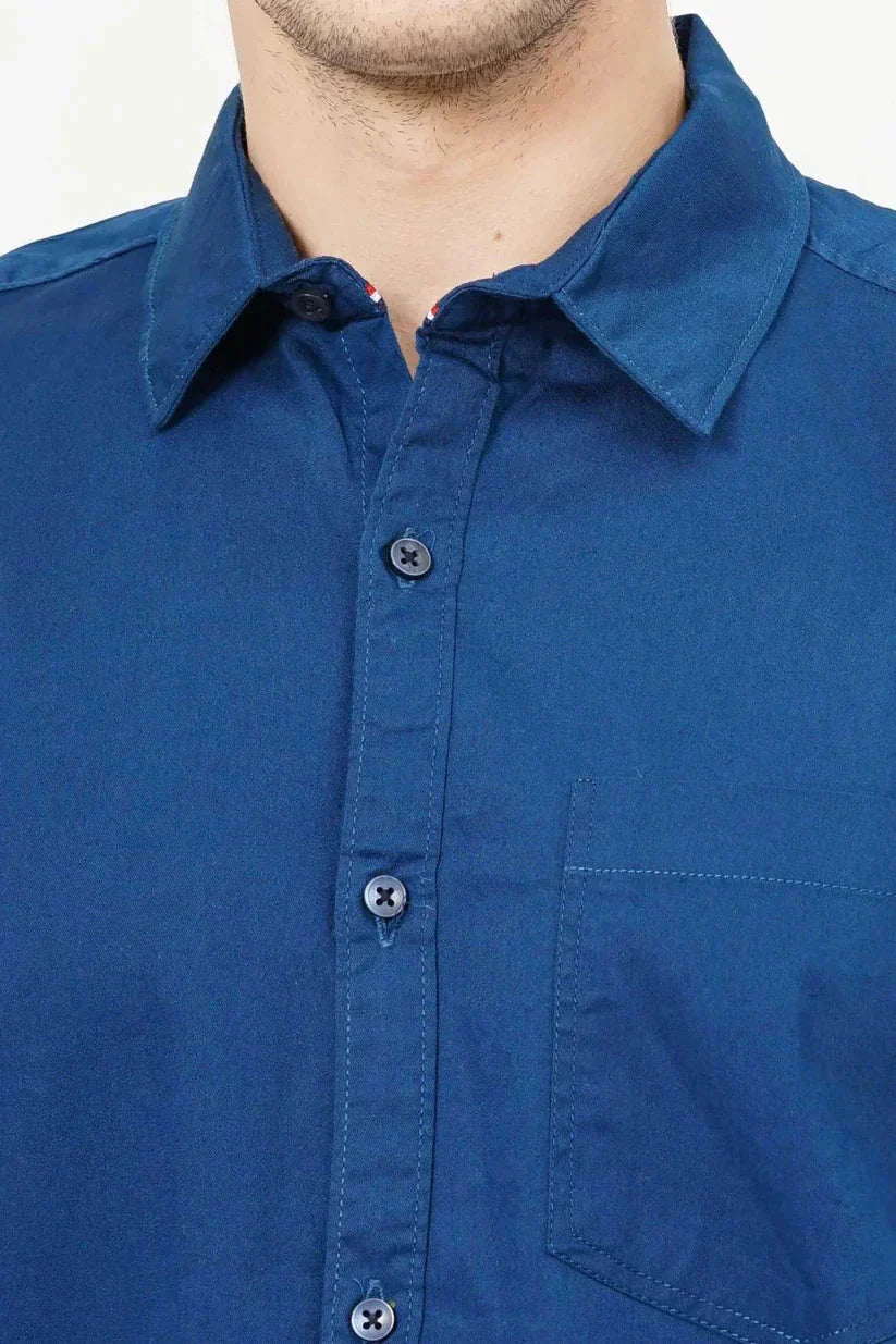 Close-up of a blue plain shirt with button details and a chest pocket.