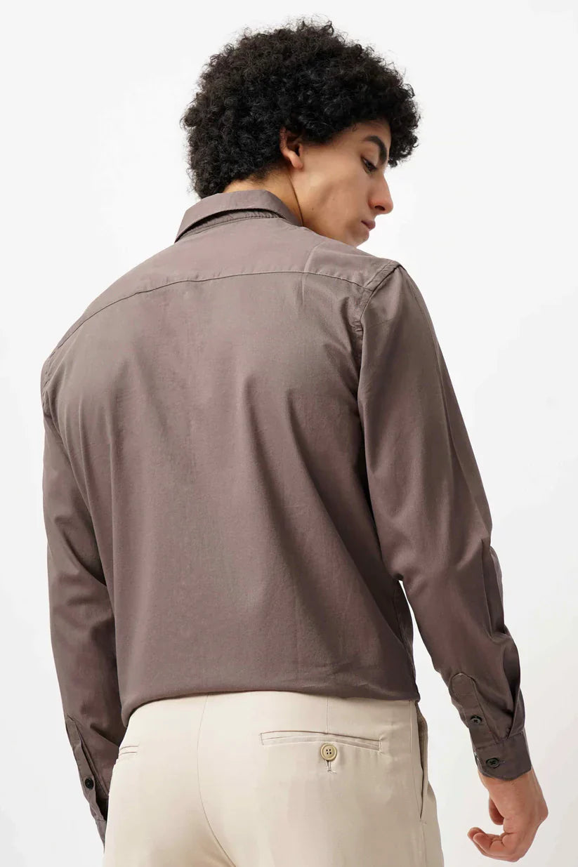 Man wearing a brown minimalist shirt made from 100% cotton.