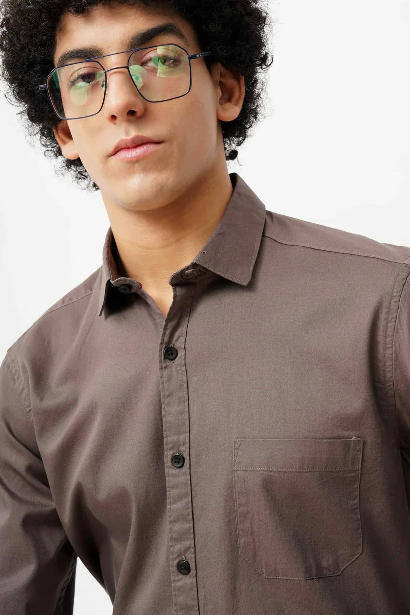 Man wearing a brown minimalist shirt made of 100% cotton.