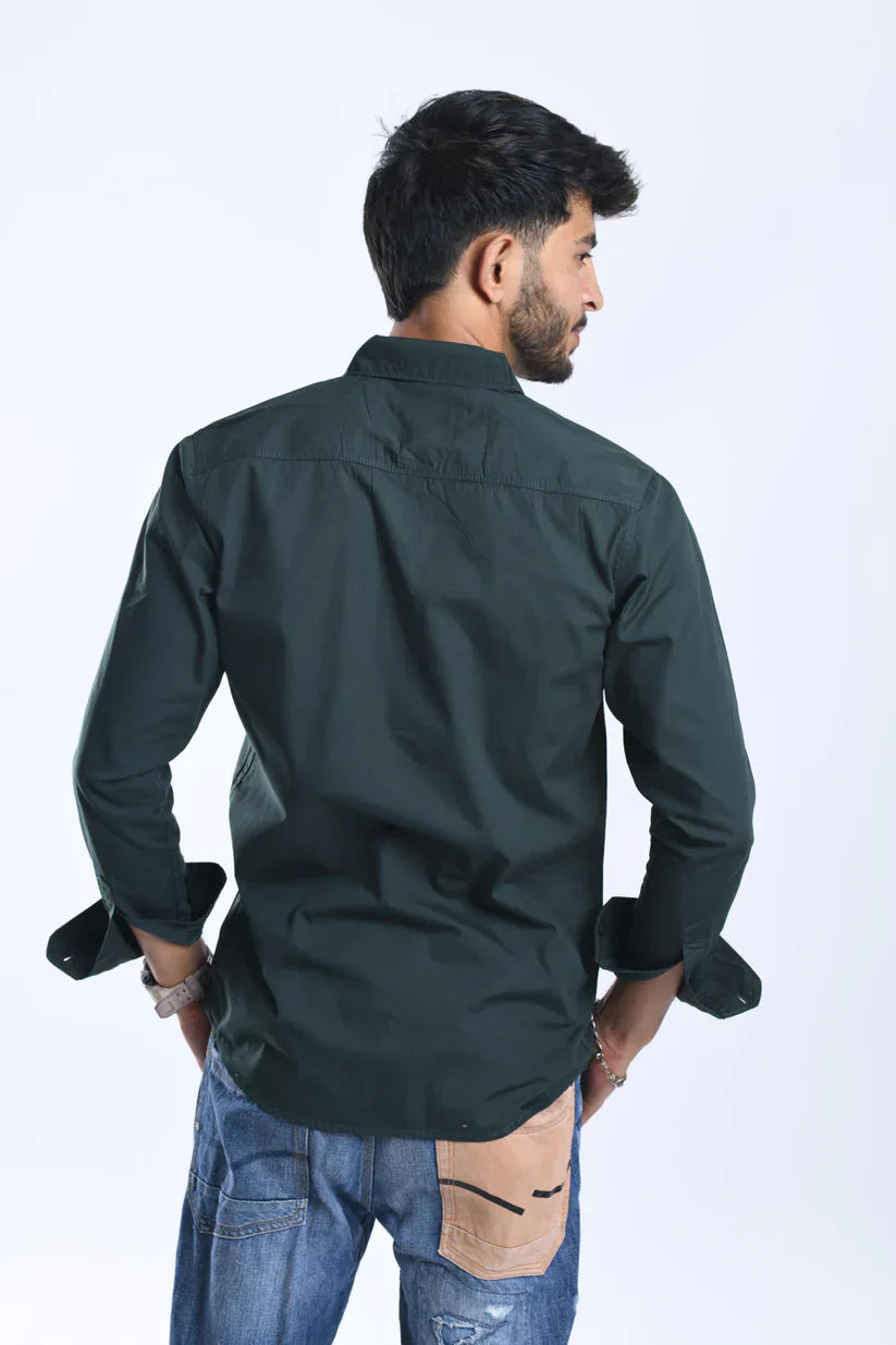 Man wearing green plain shirt made of 100% cotton.