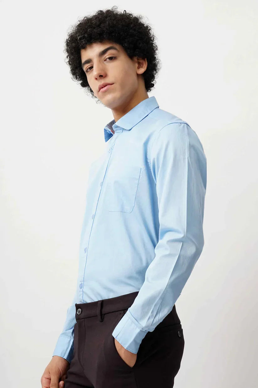 Man wearing an office blue minimalist shirt made of 100% cotton.