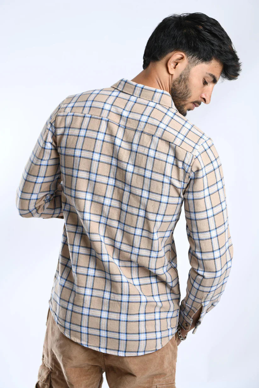 Man wearing a sand brown checked shirt made of cotton fabric.