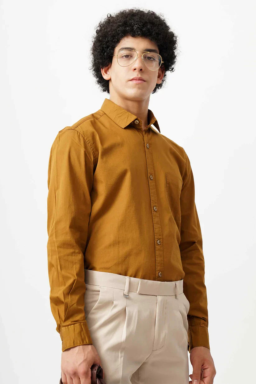 Man wearing a tan minimalist shirt made of 100% cotton.