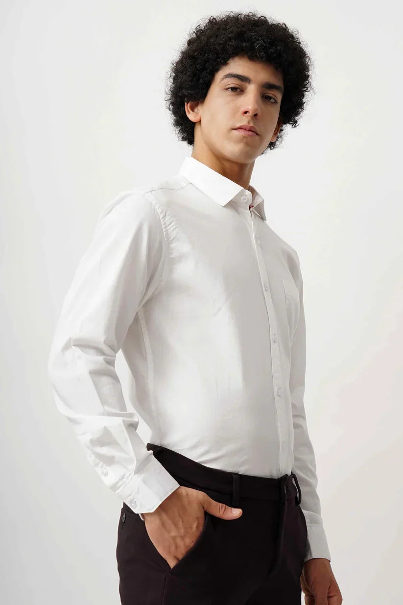 Man wearing a white minimalist shirt made from 100% cotton fabric.